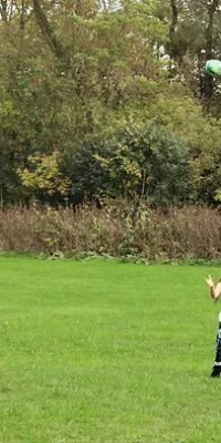 Student playing outdoors with ball at Agora Prep